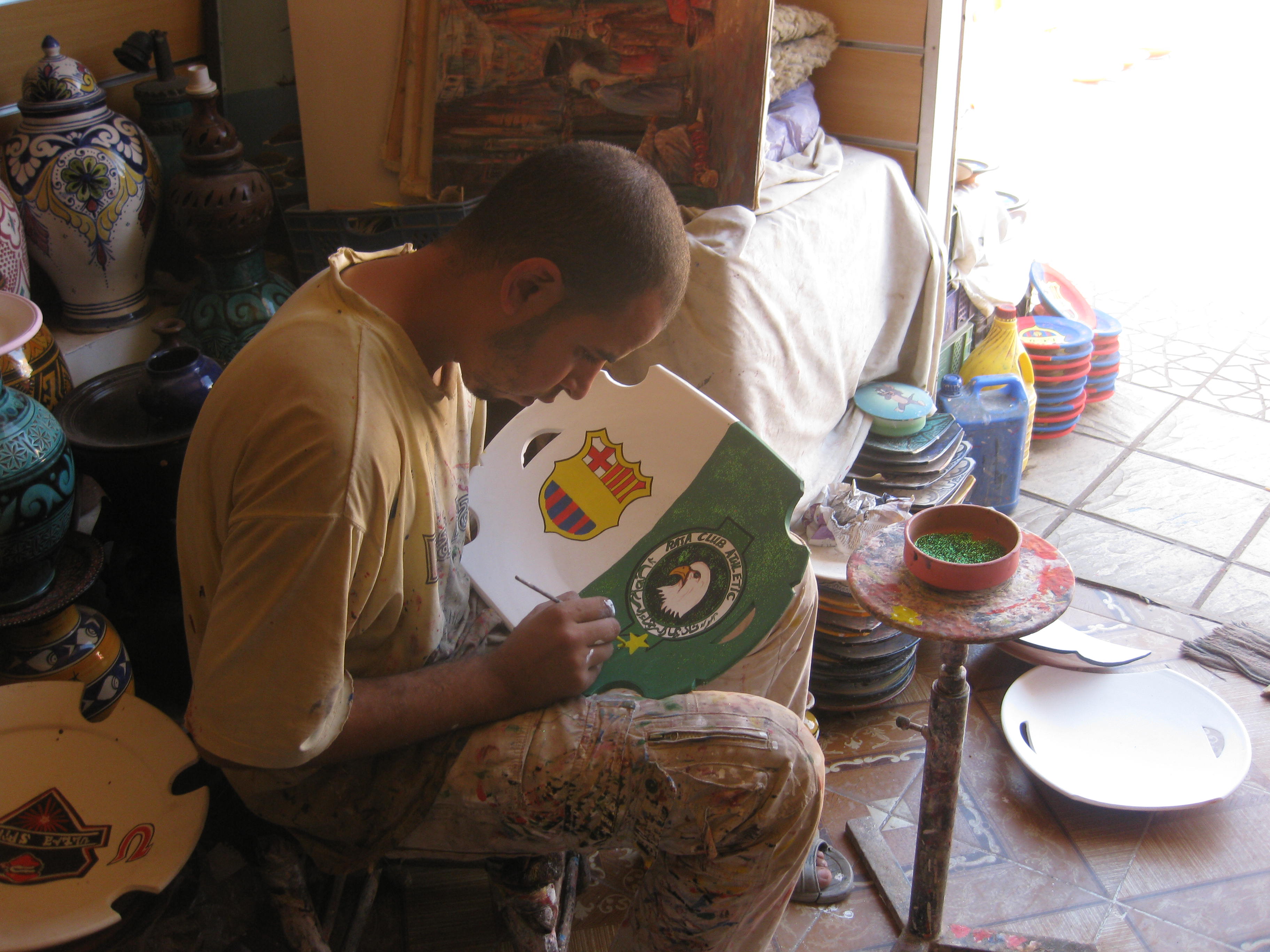 Artisan peignant une pièce de poterie à Safi