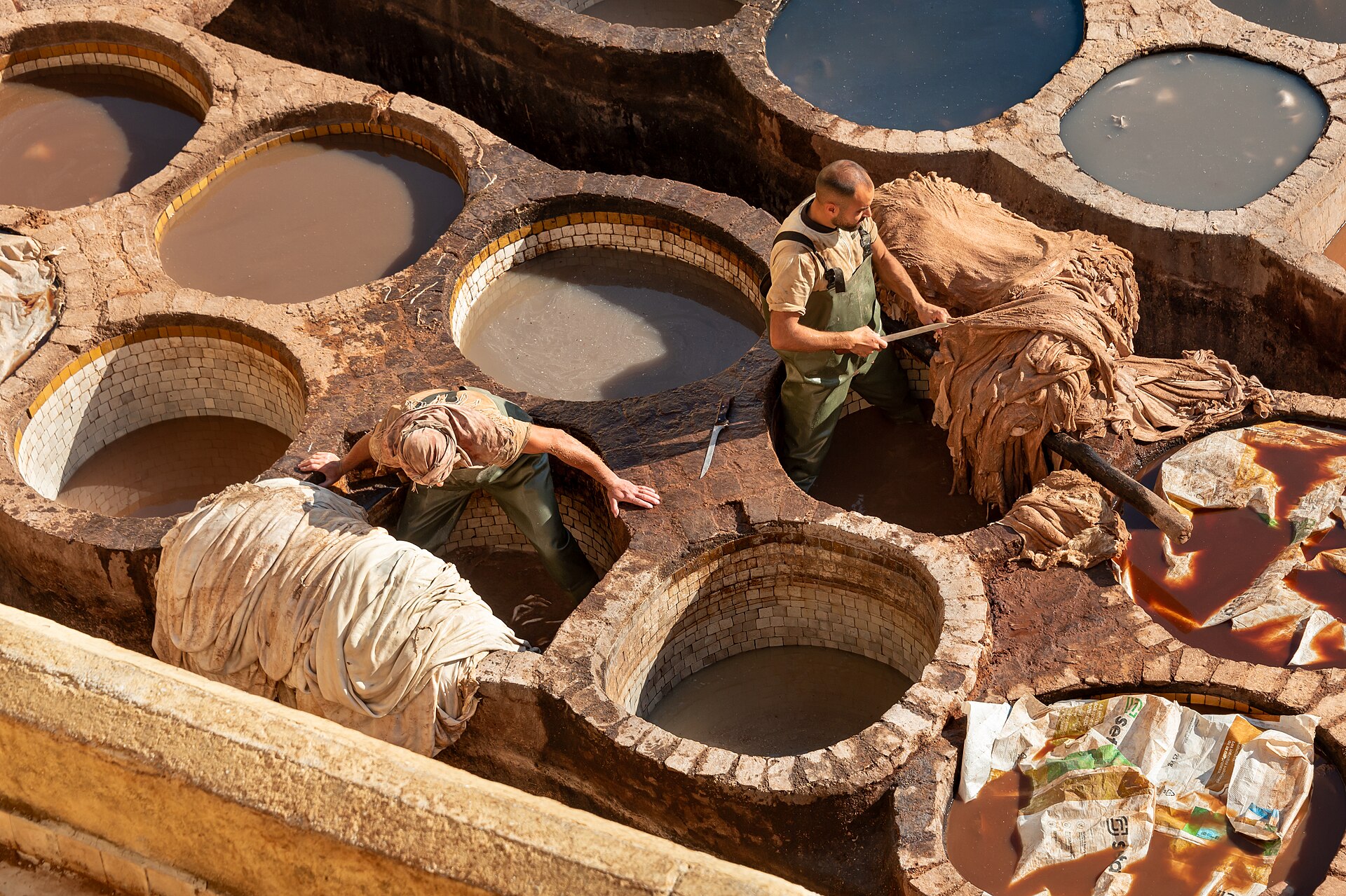 Ouvriers travaillant les peaux dans les cuves de la tannerie Chouara à Fès.