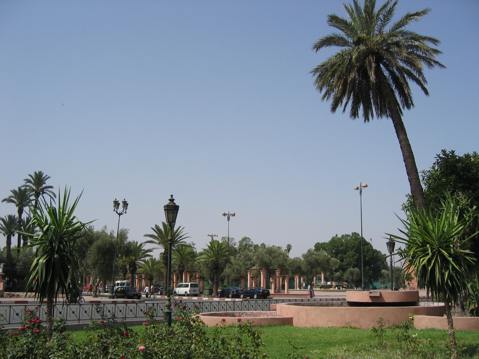 Jardin et avenue bordée de palmiers dans le quartier de Guéliz à Marrakech.
