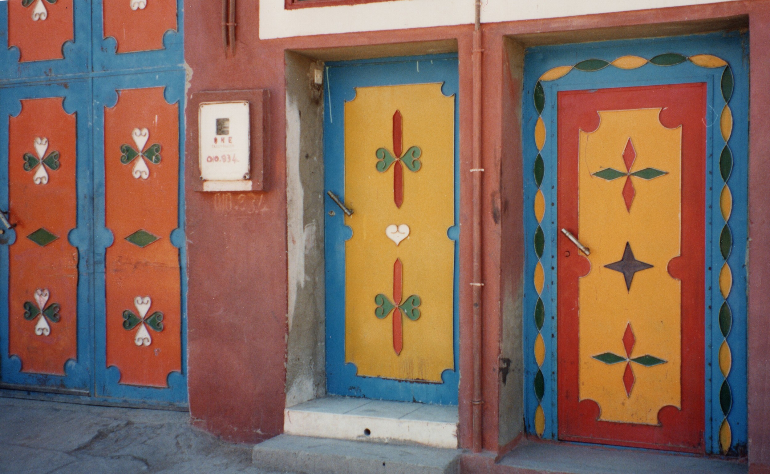 Portes peintes de couleurs vives, orange, jaune et bleu, dans une maison de Tafraout