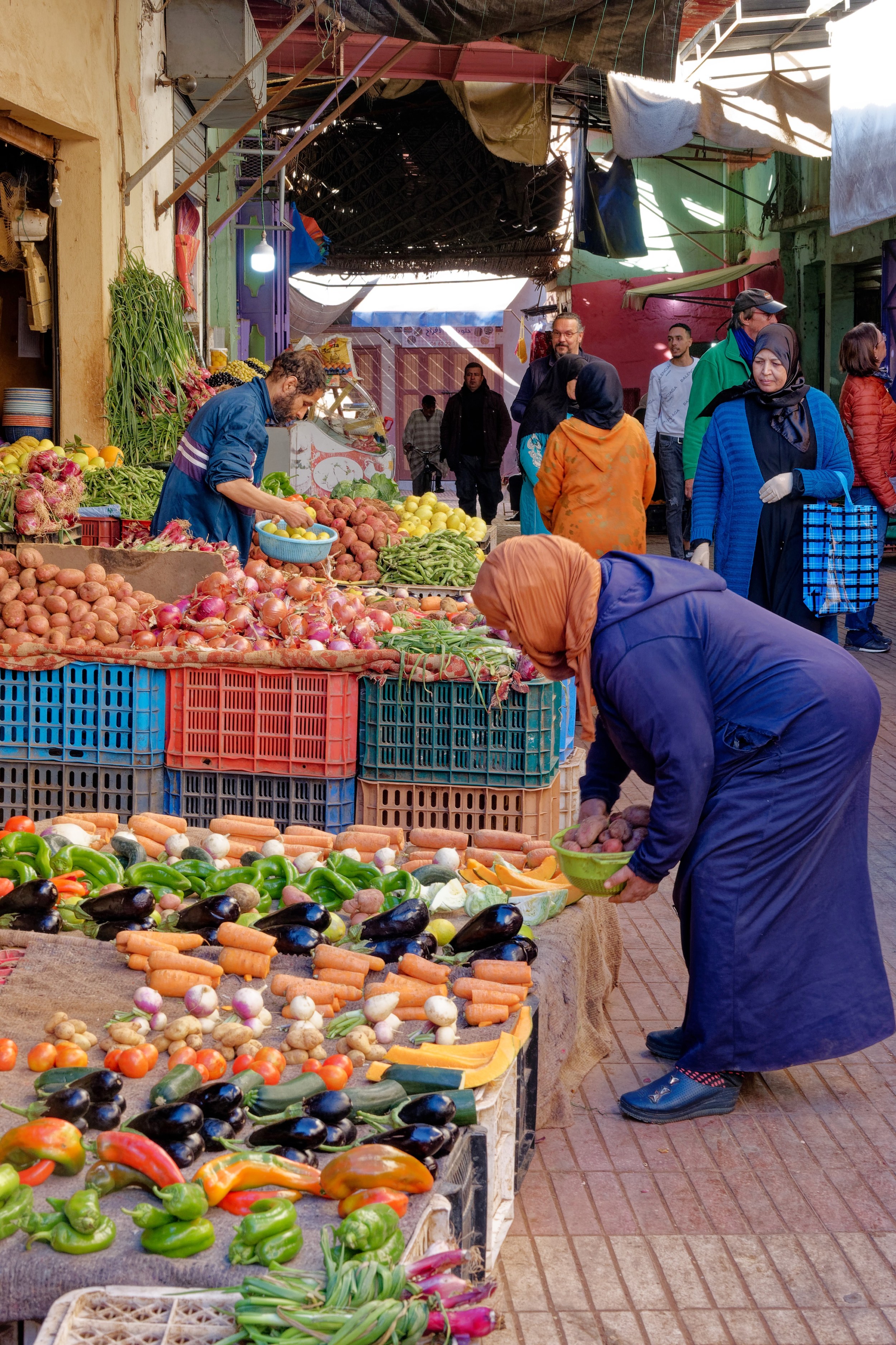 Étal de fruits et légumes dans un marché de Taroudant, avec des clientes