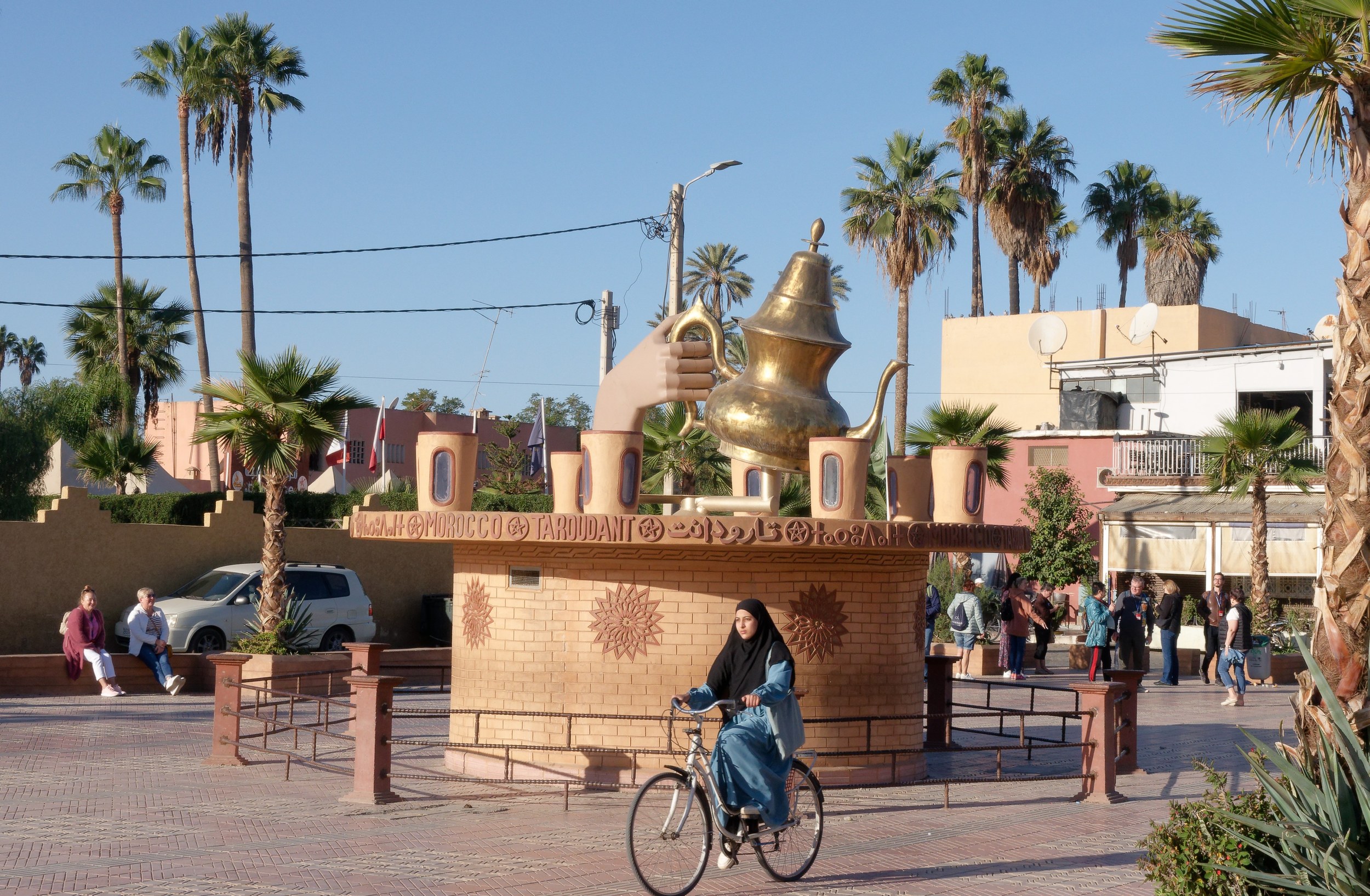 Place de Taroudant avec une fontaine, des palmiers et une cycliste