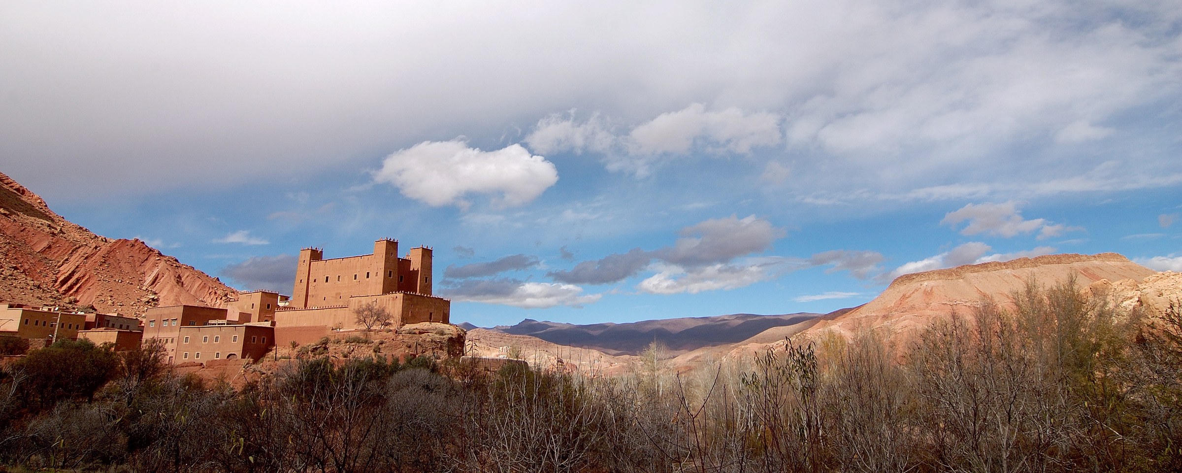 Kasbah en terre dans la vallée du Dadès, sous un ciel nuageux
